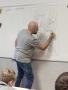 Tomasz Samojlik rysuje na tablicy